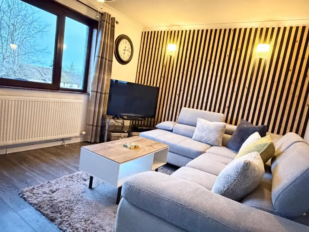a living room with a couch and a table at Mamore House Inverness in Dalneigh