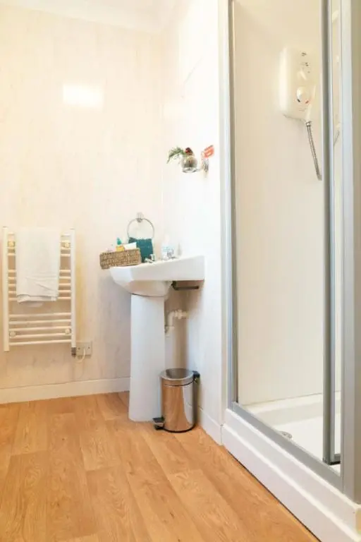 a bathroom with a sink and a shower at Dunedin House in Huntly