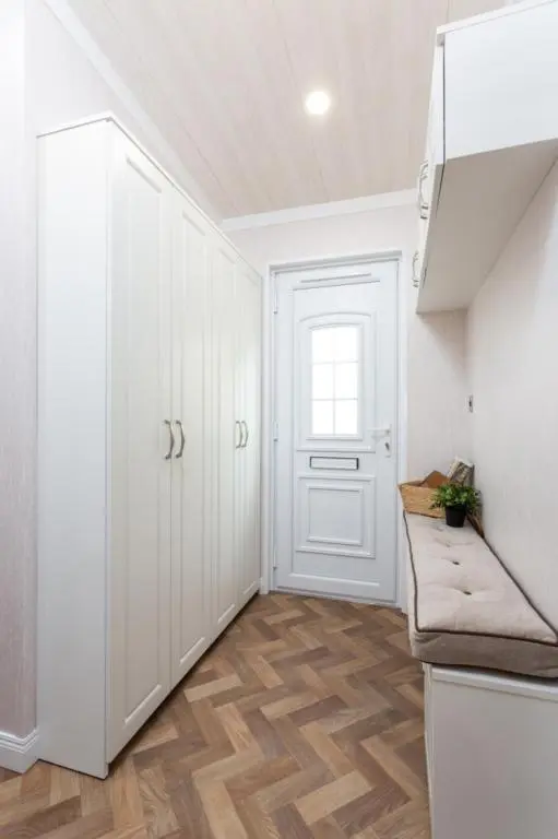 a kitchen with white cabinets and a white door at Lyndale Lodge