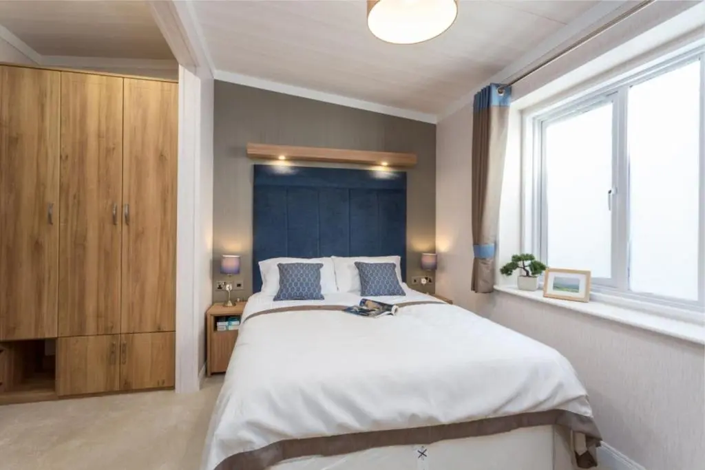 a bedroom with a large bed and a large window at Lyndale Lodge