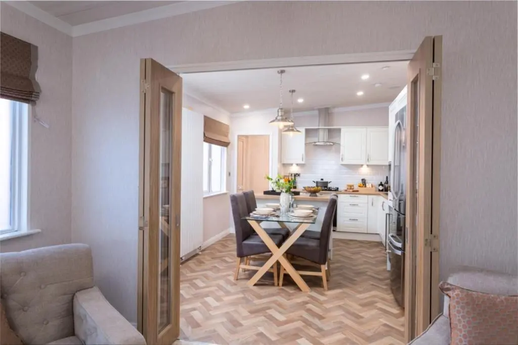 a dining room and kitchen with a table and chairs at Lyndale Lodge