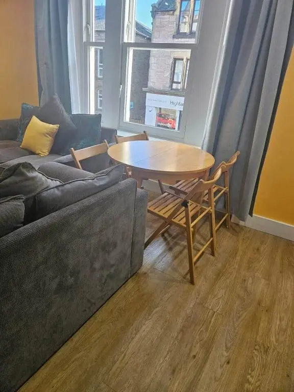 a living room with a table and a couch at City center apartment in Inverness