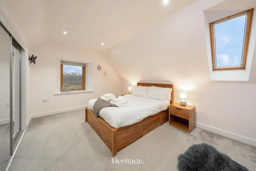 a bedroom with a large bed and a window at The Steading Family Friendly Getaway in Peterhead