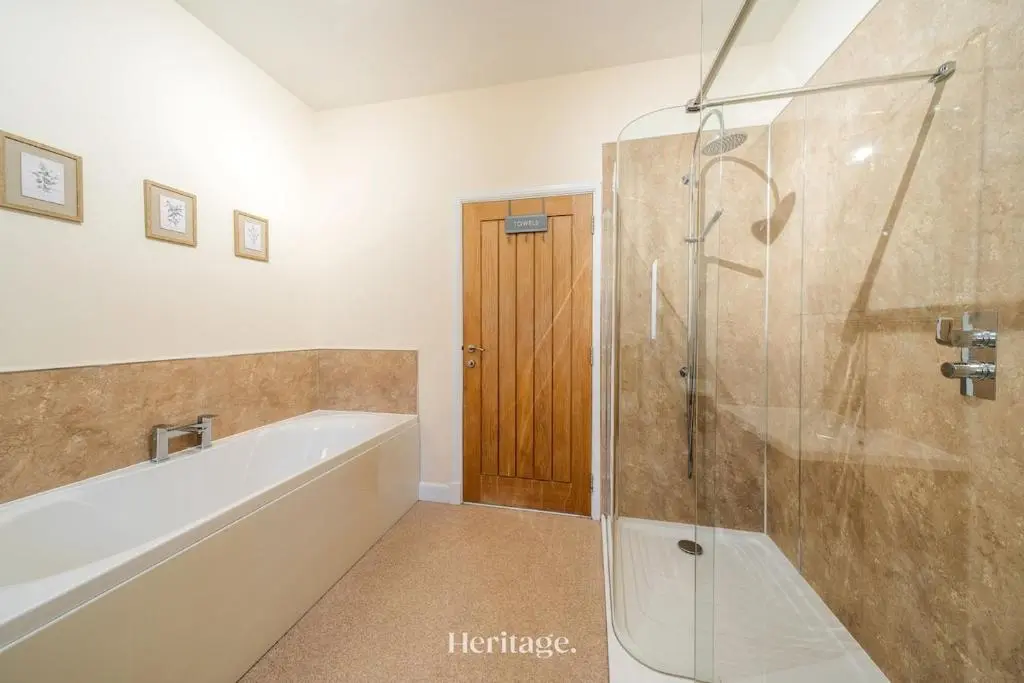 a bathroom with a tub and a glass shower at The Steading Family Friendly Getaway in Peterhead