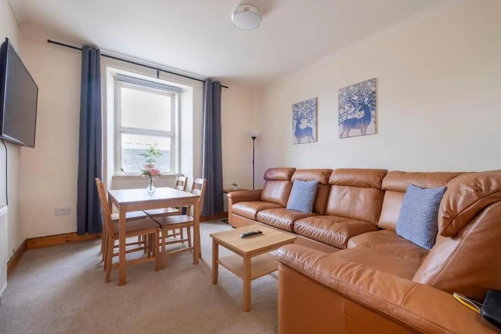a living room with a couch and a table at 2 Bed Central Apart - May Court in Inverness