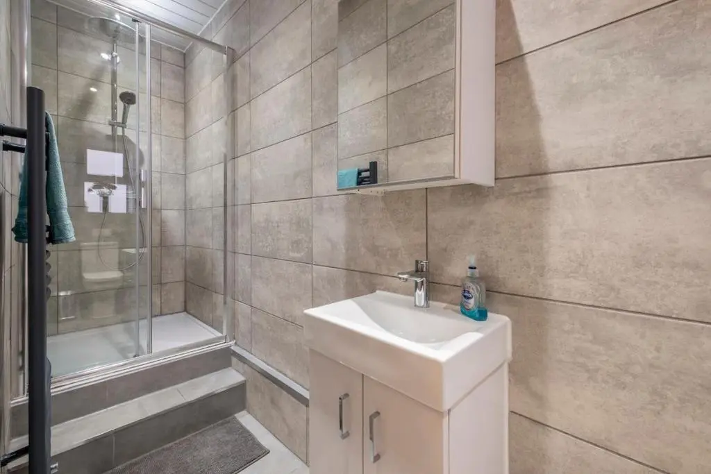 a bathroom with a sink and a shower at 2 Bed Central Apart - May Court in Inverness
