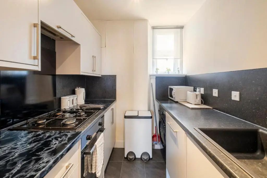 a kitchen with a stove and a counter top at 2 Bed Central Apart - May Court in Inverness