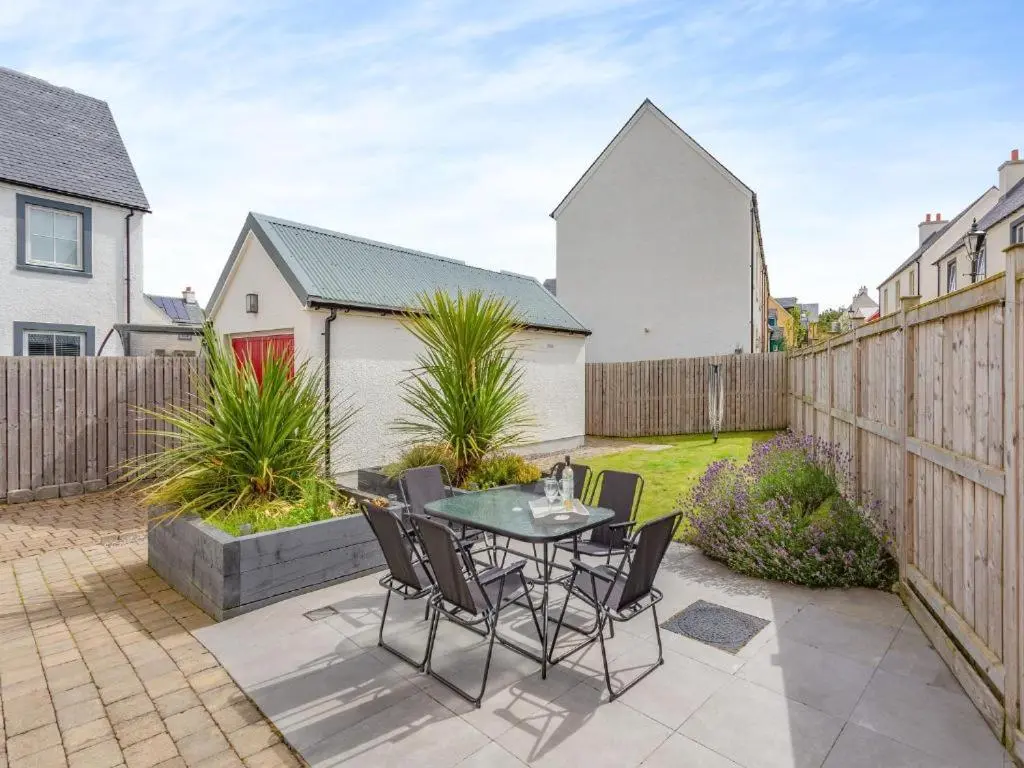 a patio with a table and chairs in a backyard at One The Loan in Inverness