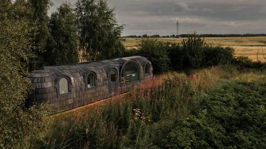 an old train sitting in the middle of a field at Boath Cabin in Auldearn