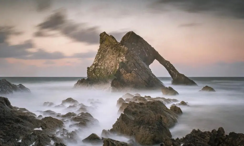 a large rock formation in the ocean with waves at Buckie Central 2 Bed Retreat in Buckie