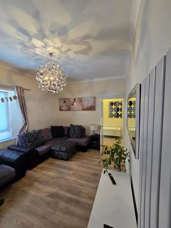 a living room with a couch and a chandelier at Nanny bambi's three bedroom's in Inverness