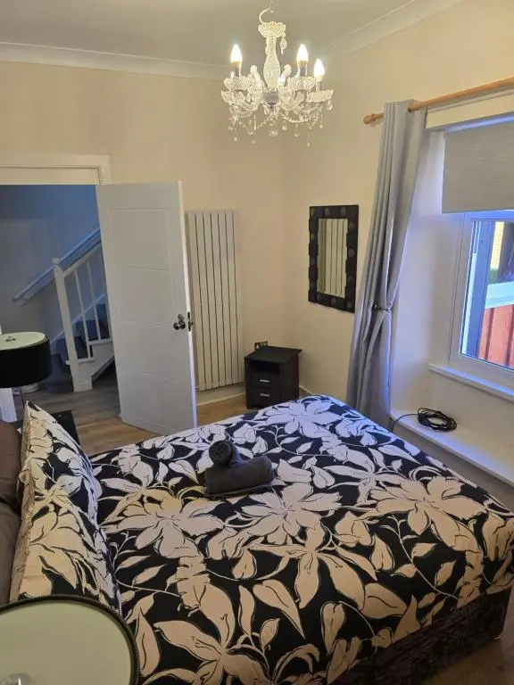 a bedroom with a bed and a chandelier at Nanny bambi's three bedroom's in Inverness