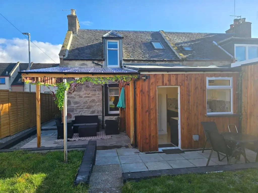 a house with a deck and a patio at Nanny bambi's three bedroom's in Inverness