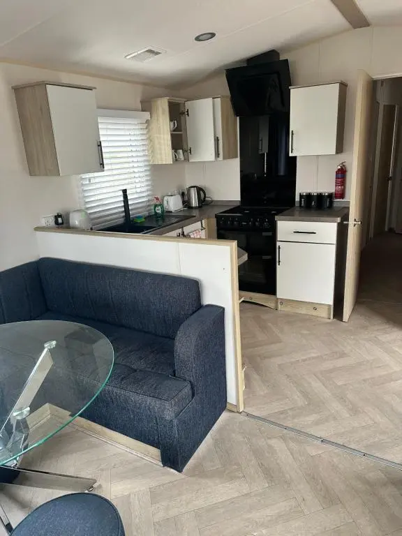 a living room with a couch and a kitchen at Moonstone in Lossiemouth