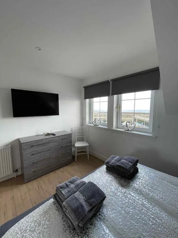 a bedroom with a tv and a bed with two pillows at Apartment in Banff in Banff