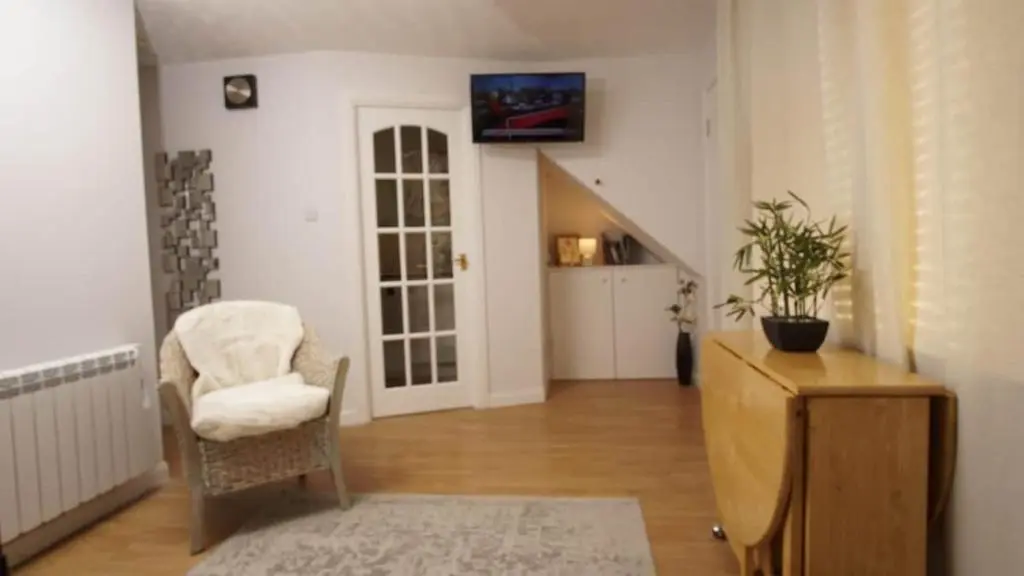 a living room with a chair and a table at Cosy flat in Inverness