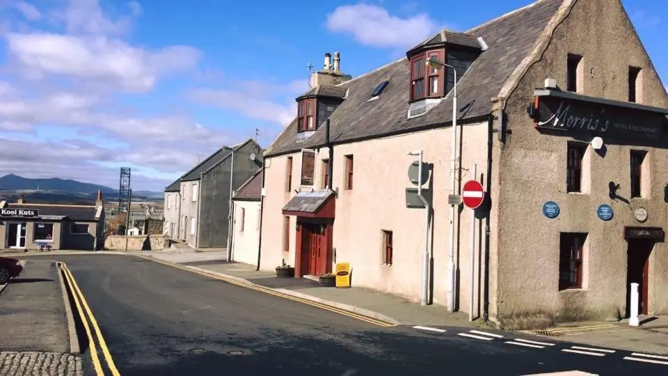 an old building on the side of a street at Morris Gardens Apartments in Oldmeldrum