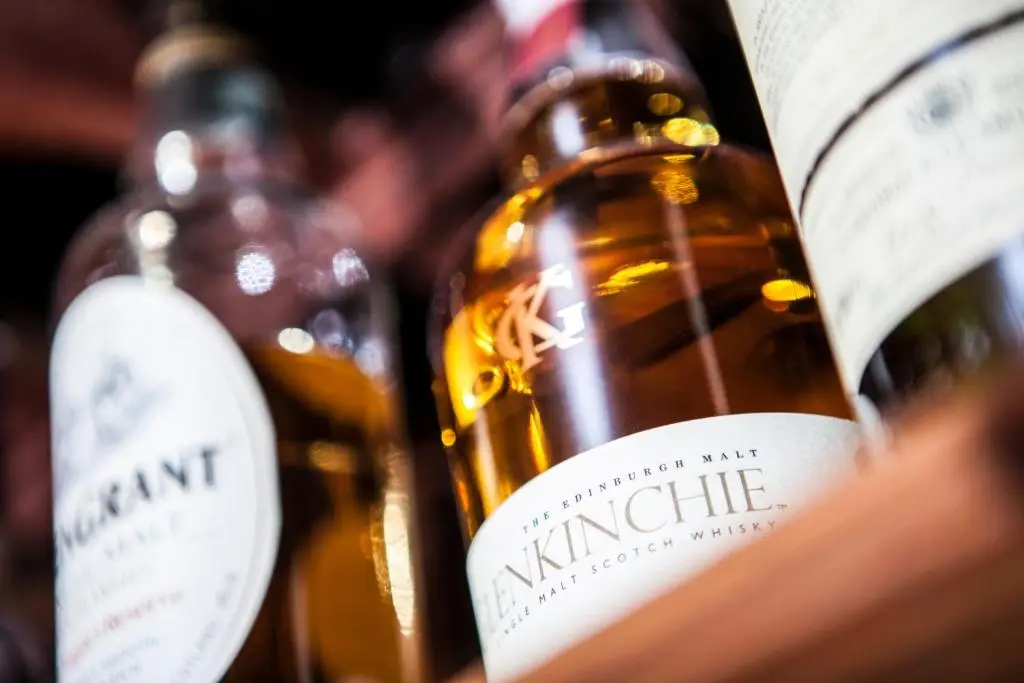 a row of bottles of wine with labels on them at Burnett Arms Hotel in Banchory