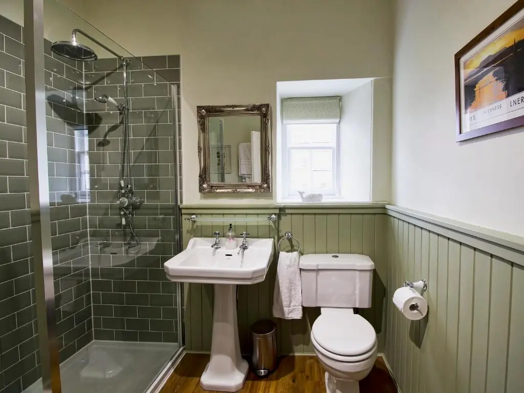 a bathroom with a sink and a toilet and a shower at Drummuie House in Golspie