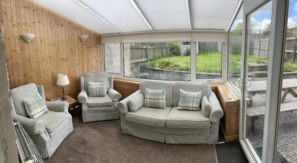 a living room with two chairs and a couch at Carrick House in Kingussie