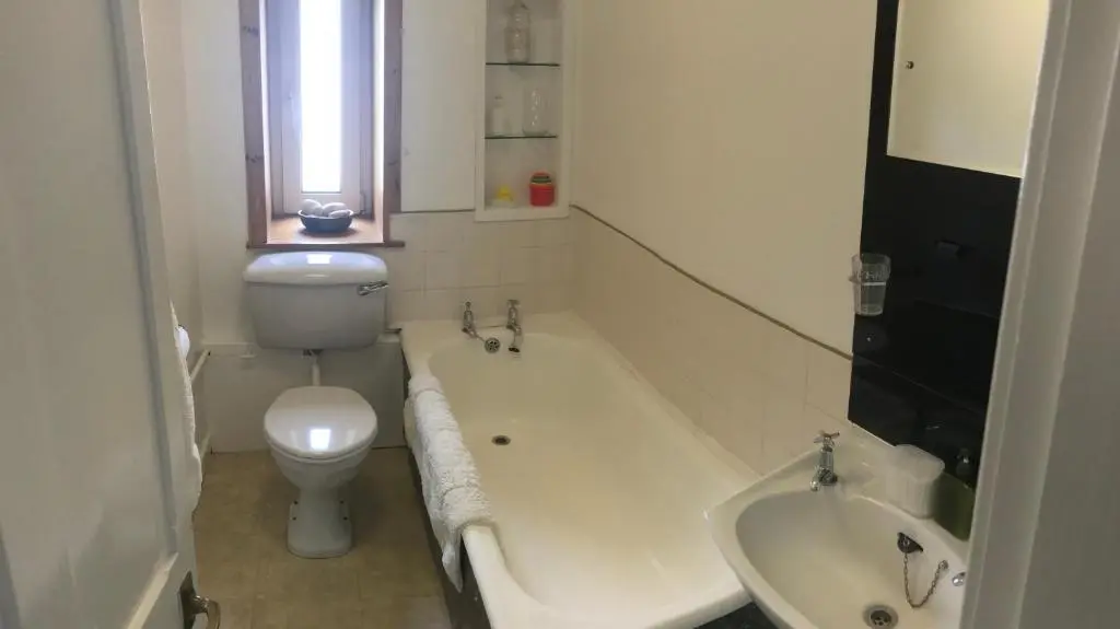 a bathroom with a toilet and a tub and a sink at Carrick House in Kingussie