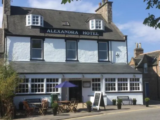 a hotel with a table and chairs in front of it at Alexandra Hotel in Ballater