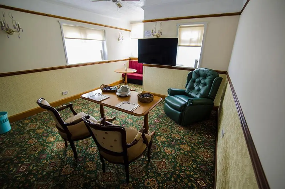 a living room with a table and a chair at Elgin City Centre Torr House hotel in Elgin