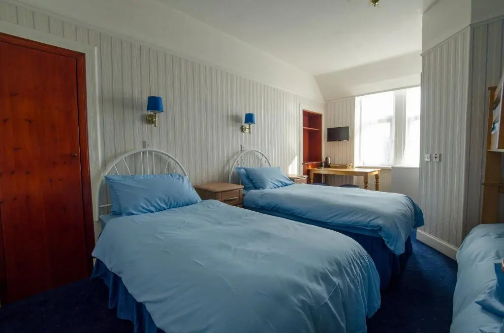 a hotel room with two beds and a window at Elgin City Centre Torr House hotel in Elgin