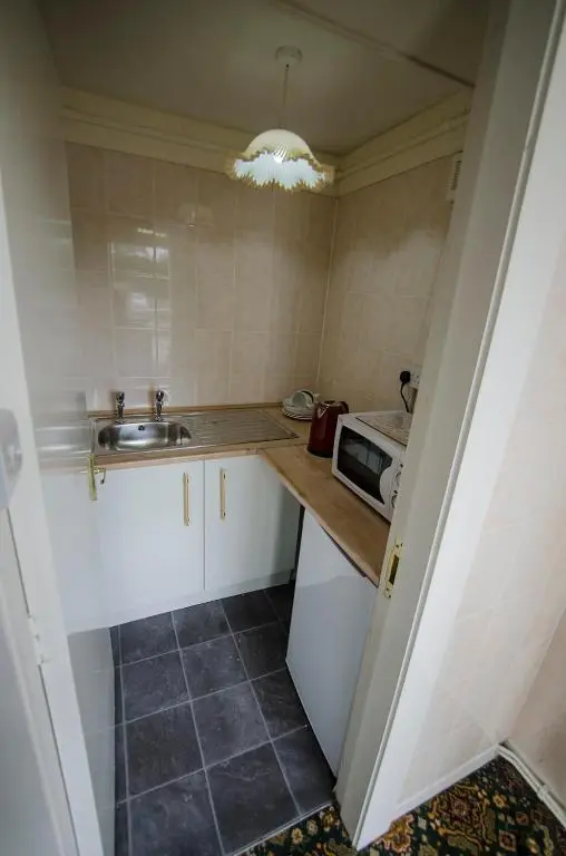 a small kitchen with a sink and a microwave at Elgin City Centre Torr House hotel in Elgin