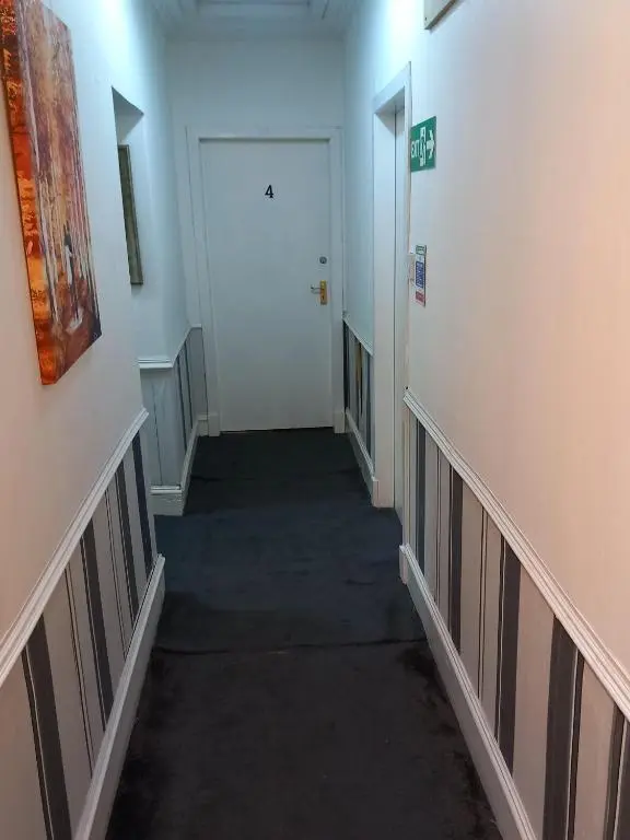 a hallway with a white door and a white hallway sidx sidx sidx at Aberdeen Arms Hotel Tarland in Tarland