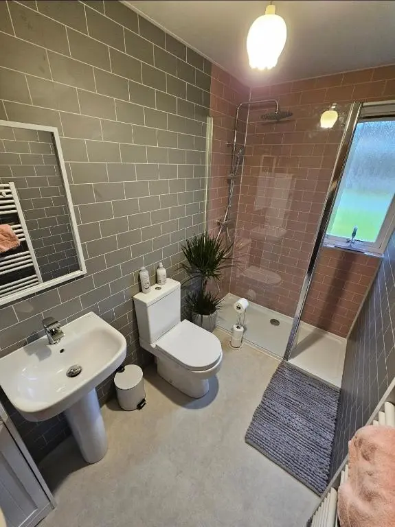 a bathroom with a toilet and a sink and a shower at Home Comforts in Peaceful 2 Acres in Inverness