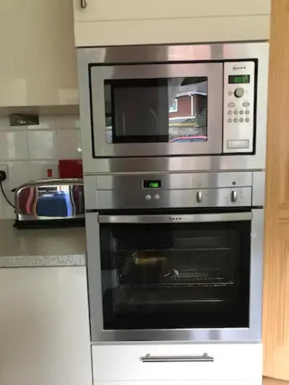 a microwave sitting on top of an oven in a kitchen at Home Comforts in Peaceful 2 Acres in Inverness