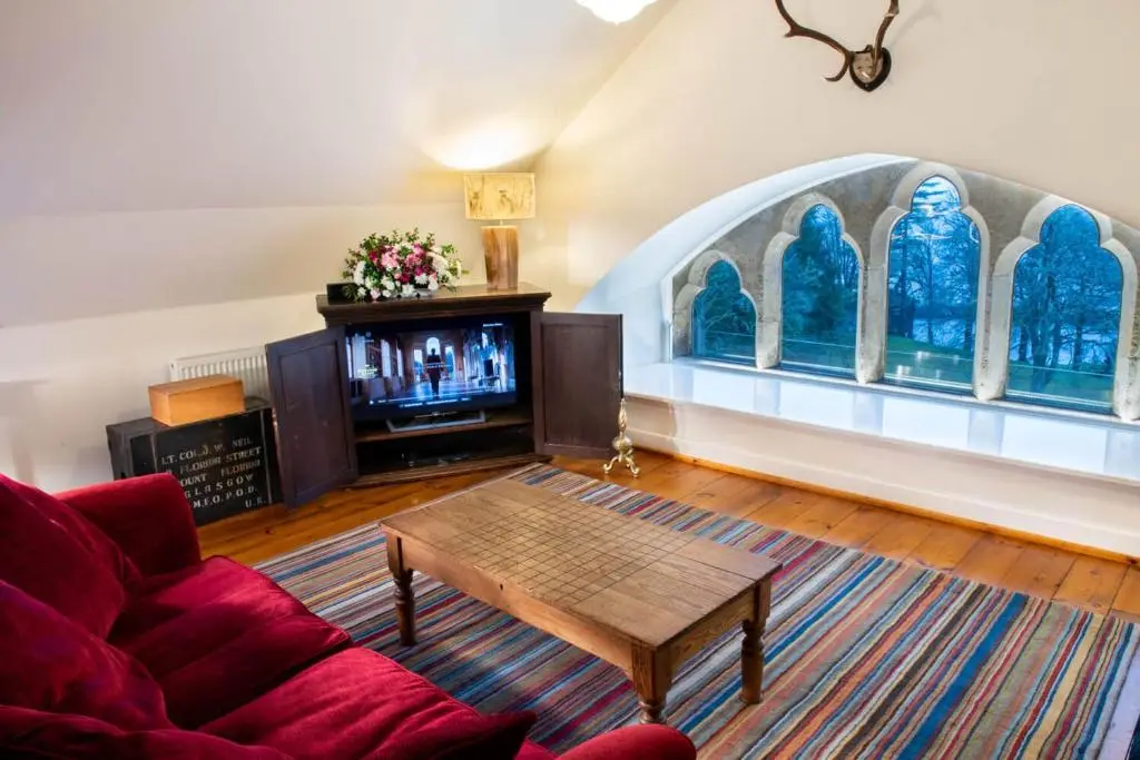 a living room with a couch and a table and a tv at Boys Dormitory in Fort Augustus