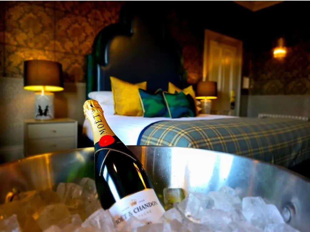 a bottle of champagne in a tub in a bedroom at Beaufort Hotel in Inverness