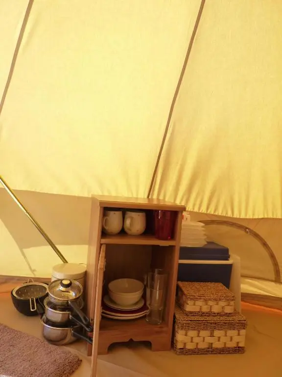 a wooden shelf with dishes and plates in a tent at Inver Coille Campsite in Fort Augustus