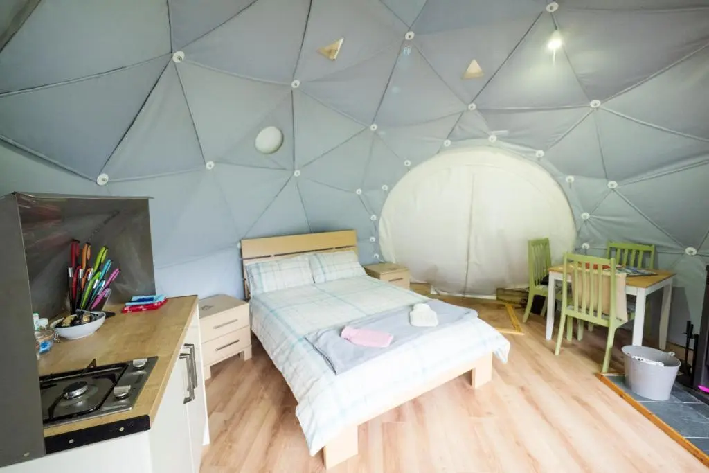 a bedroom with a bed and a kitchen and a table at Inver Coille Campsite in Fort Augustus