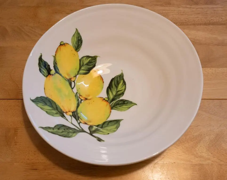 a white plate with a bunch of lemons on it at Elgin Self Catering Holiday Cottage in Elgin