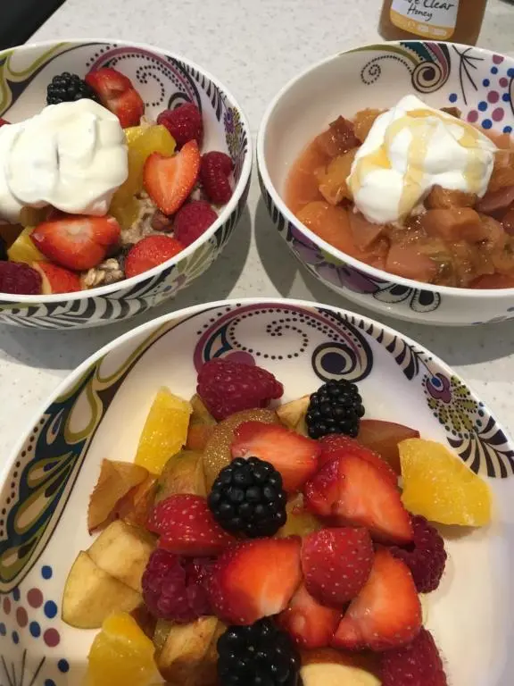 three bowls of food with fruit on plates on a table at Ronas House in Inverness