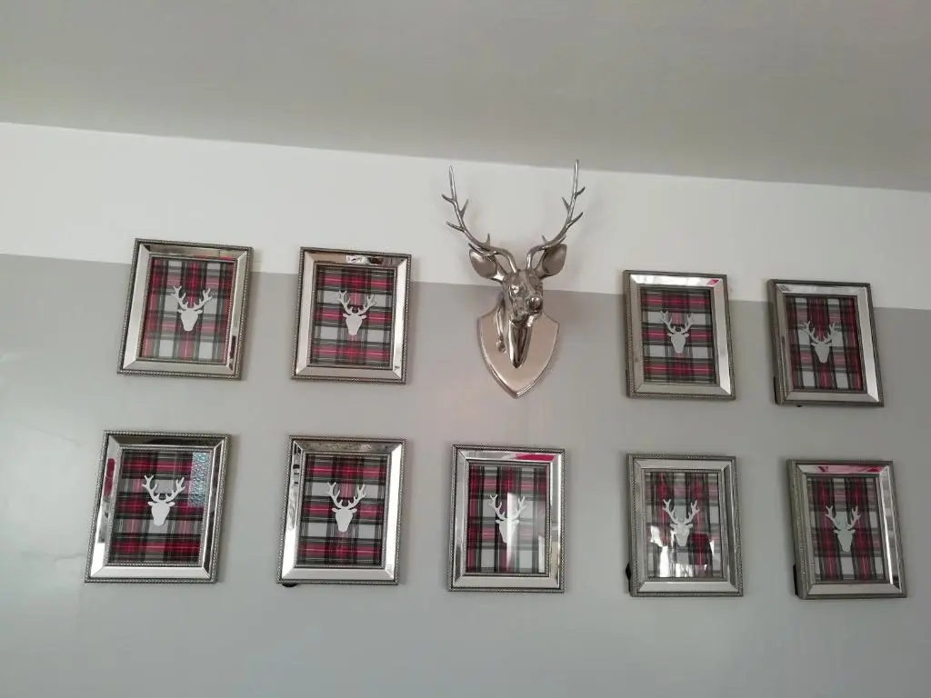a group of framed pictures on a wall with a deer head at Argyle Guest House in Tomintoul