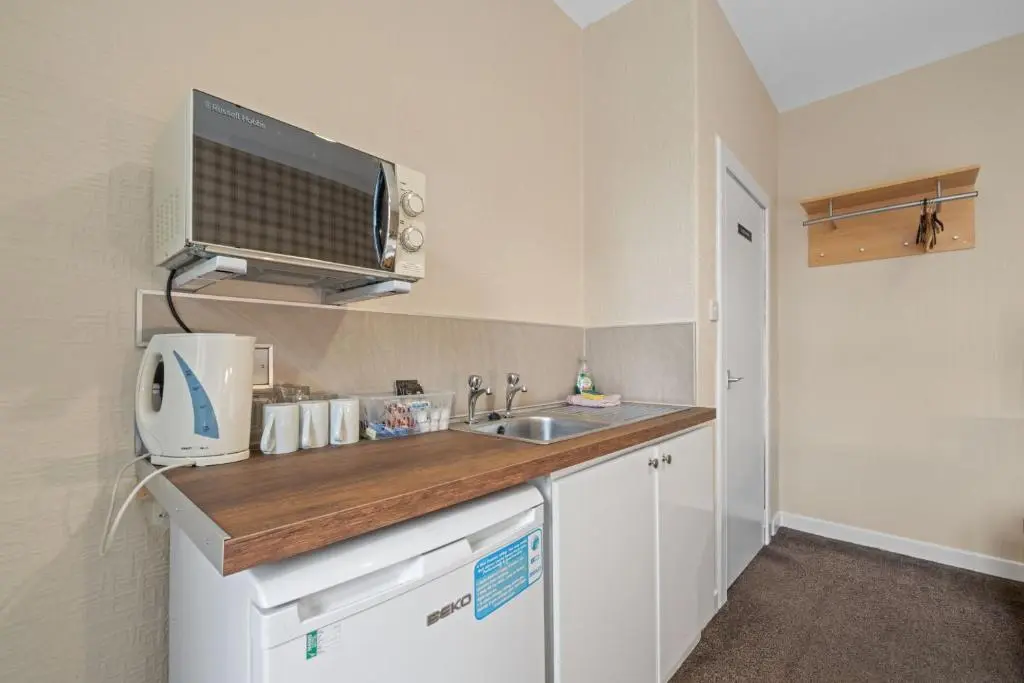 a small kitchen with a sink and a microwave at mySTAYINN Strathblane House in Inverness