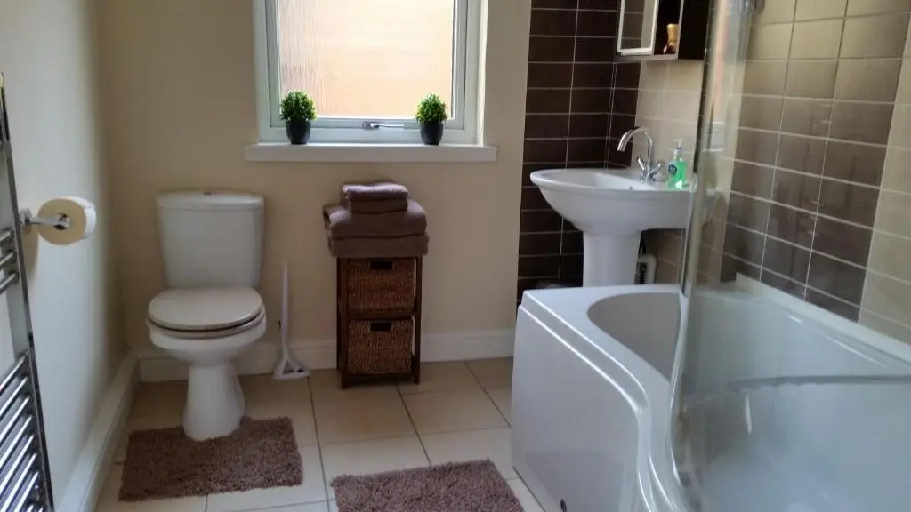 a bathroom with a toilet and a sink and a tub at Nairnia in Nairn