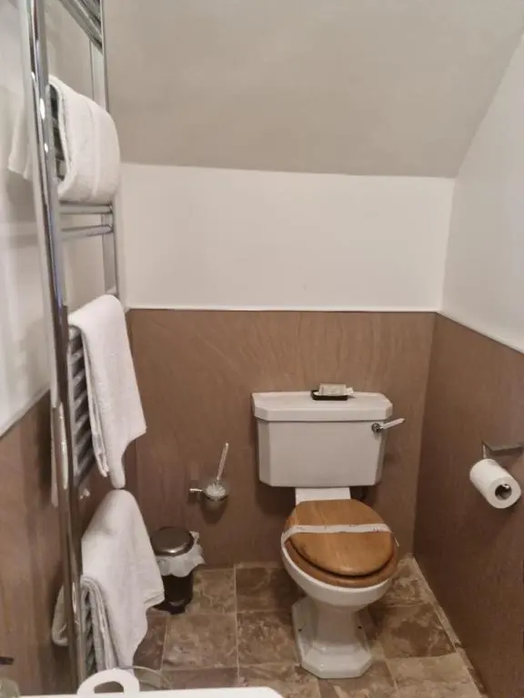 a small bathroom with a toilet with a wooden seat at St Michaels Guest House in Elgin