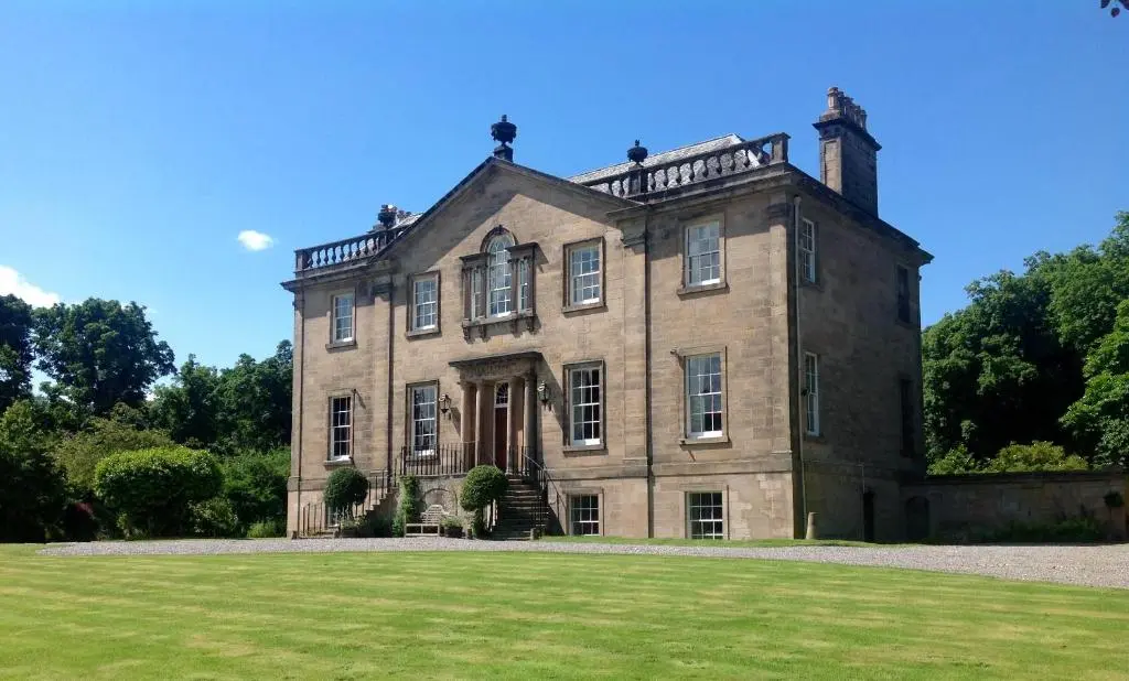 a large brick house with a grassy yard at Dalvey House in Forres