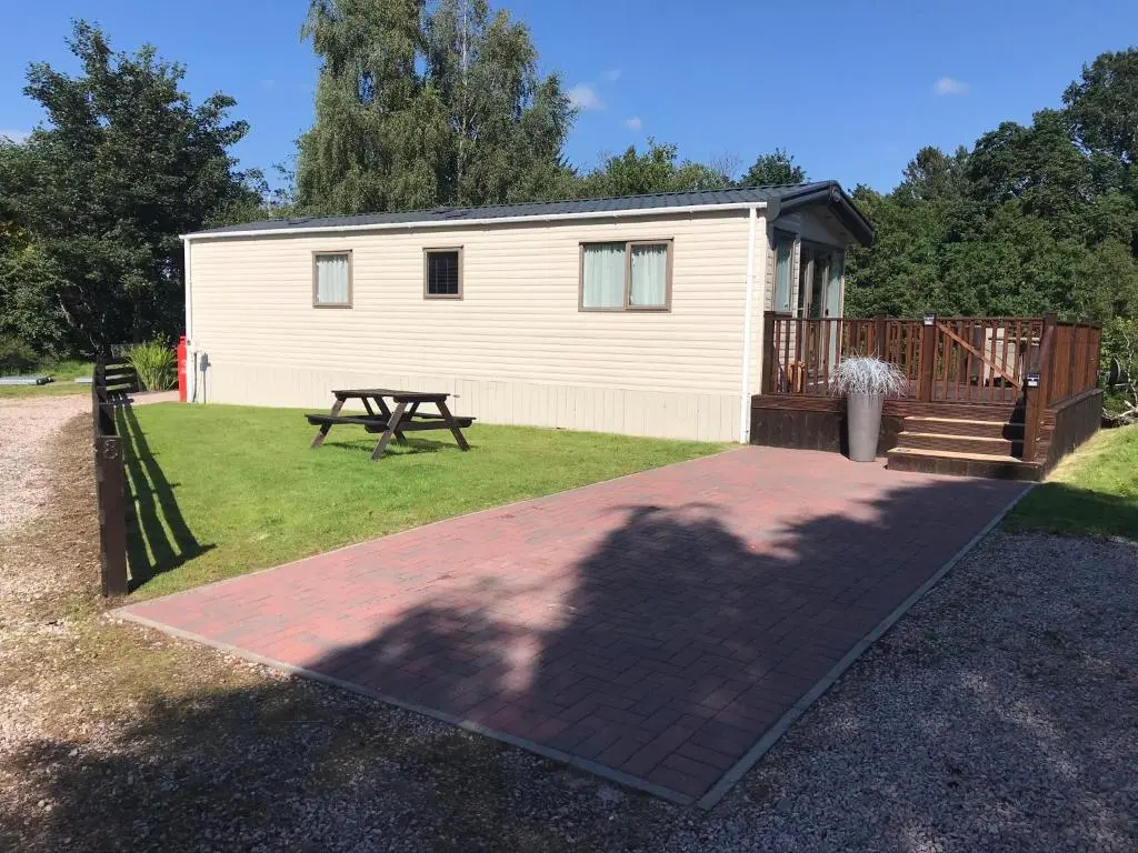 a house with a picnic table in front of it at Riverbank Lodge in Aviemore