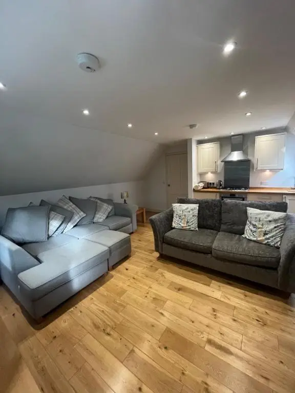 a living room with a couch and a kitchen at Wee Corsee in Nairn