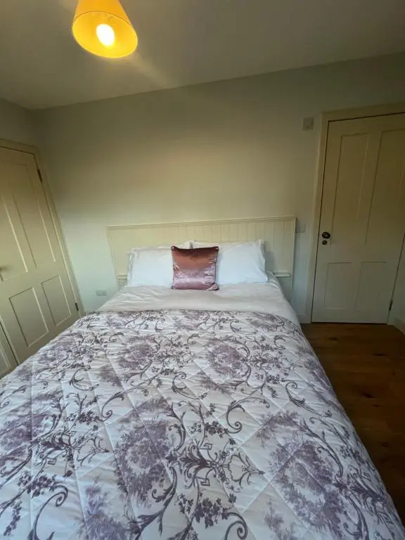 a bedroom with a bed with a purple and white blanket at Wee Corsee in Nairn