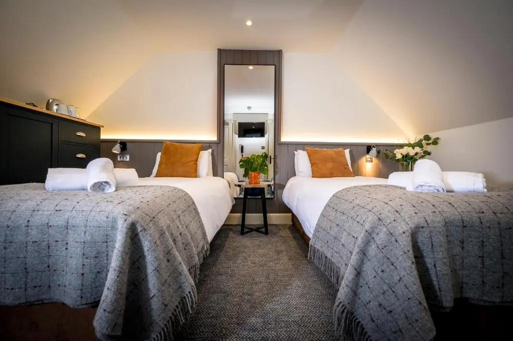 a hotel room with two beds and a mirror at Loch Ness Inn in Drumnadrochit