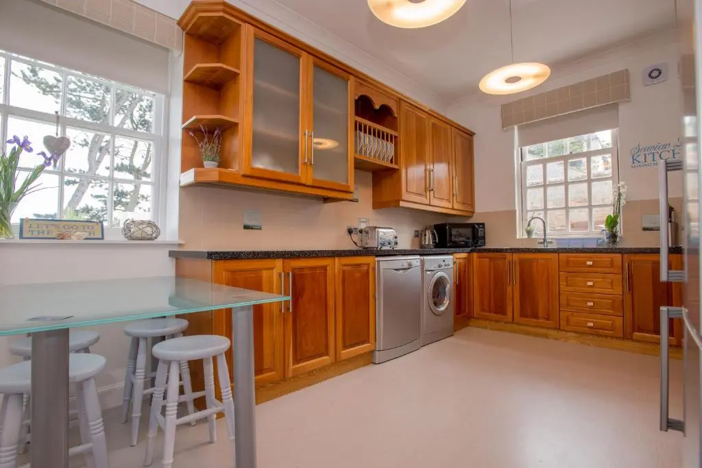 a kitchen with wooden cabinets and a counter top at Sea View Lodge in Nairn