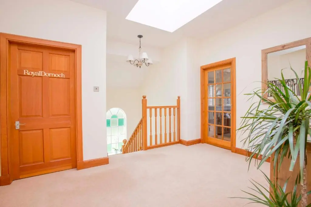 a hallway with a wooden door and a staircase at Sea View Lodge in Nairn