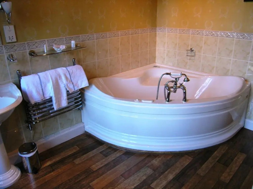 a bath tub in a bathroom with a sink and towels at Atholl Arms in Blair Atholl